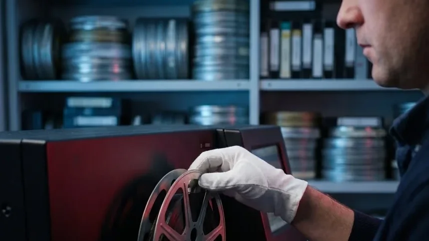 Archivist loading a 35mm film reel onto a film scanner